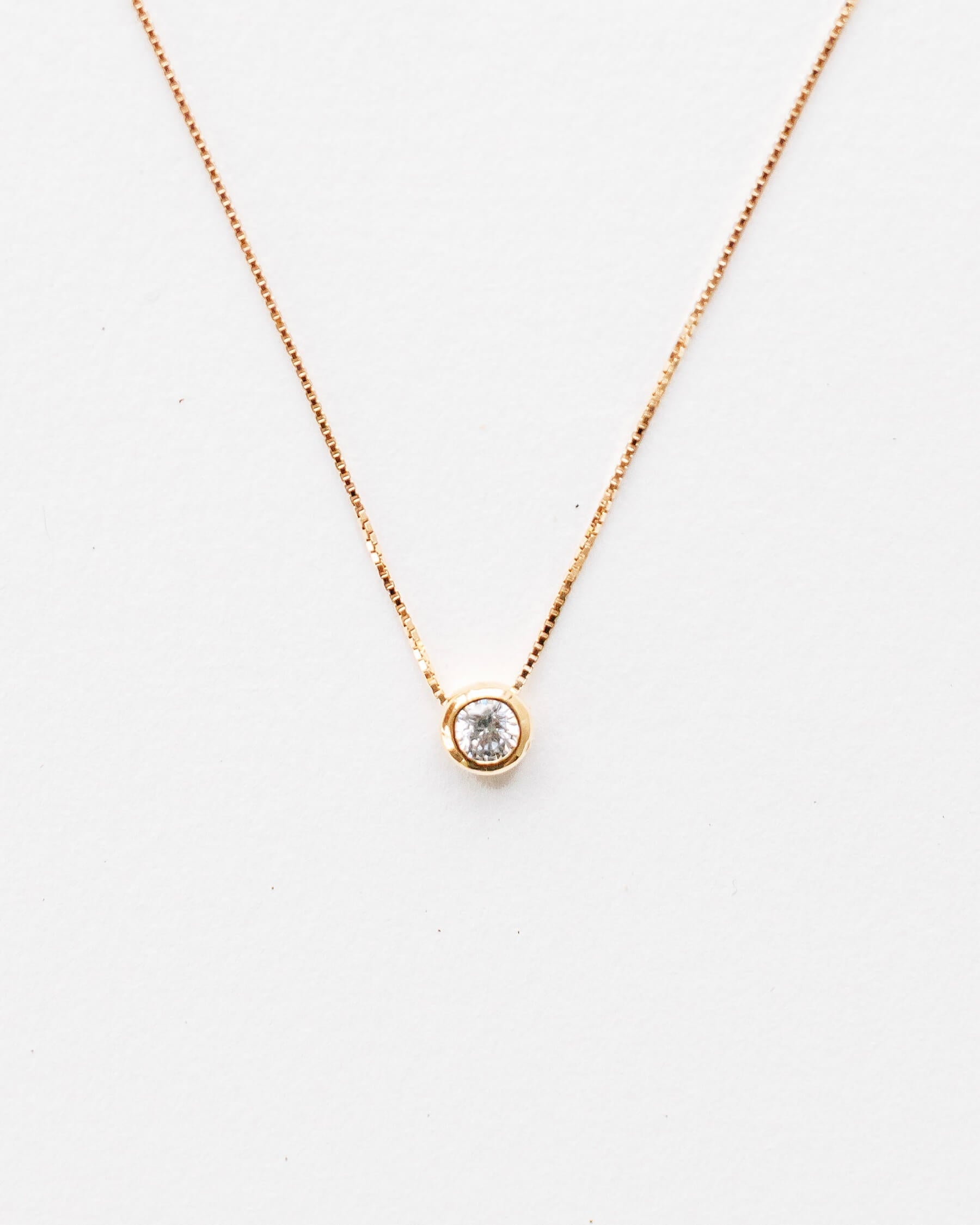 Halsband i guldpläterat 925 Sterling silver med tunn Veneziakedja och ett hänge med en vit Kubisk zirkonia i bezelfattning.