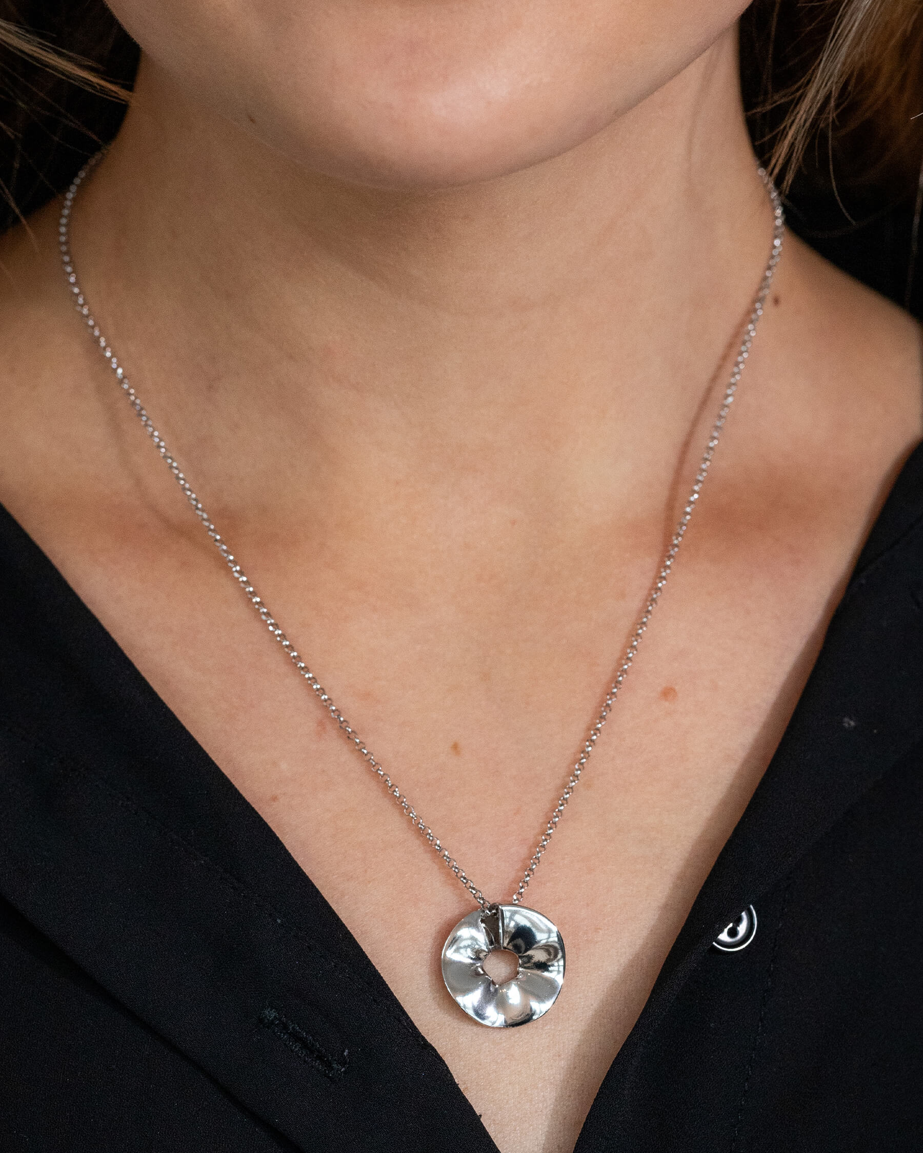 Kvinna med svart topp och silverhalsband.