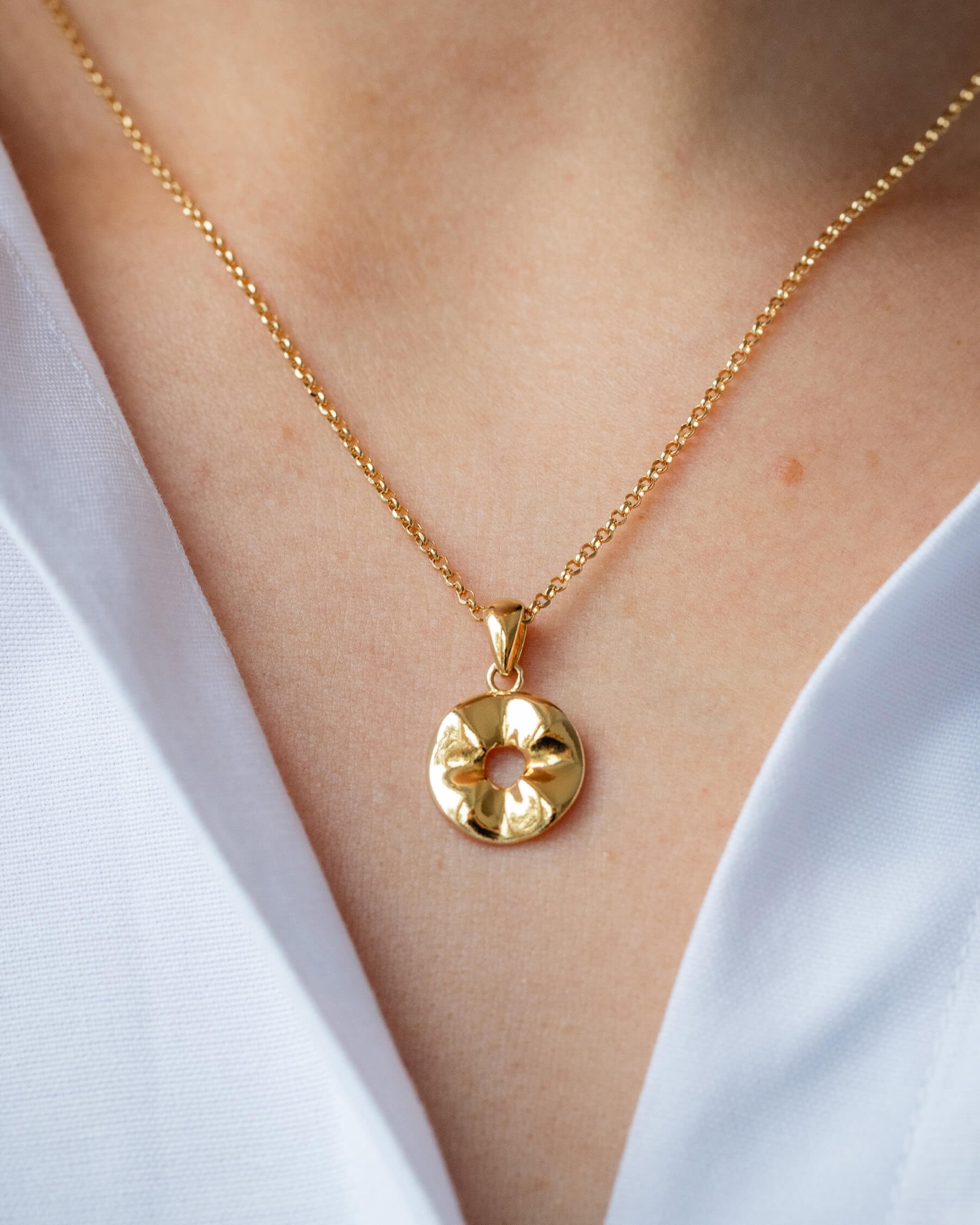 Kvinna med vit skjorta och halsband i guldpläterat sterling silver.