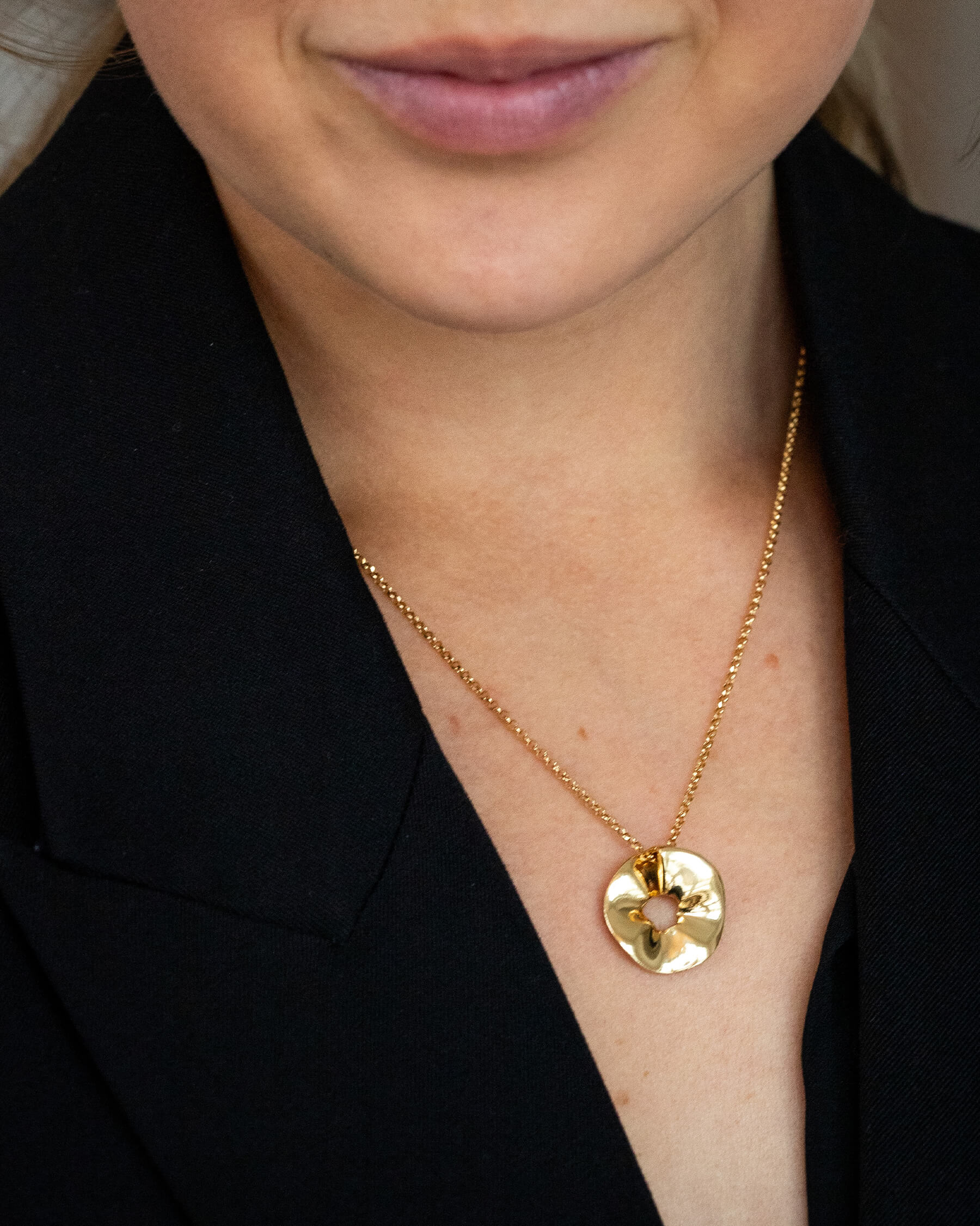 Kvinna i svart topp och halsband i guldpläterat sterling silver.