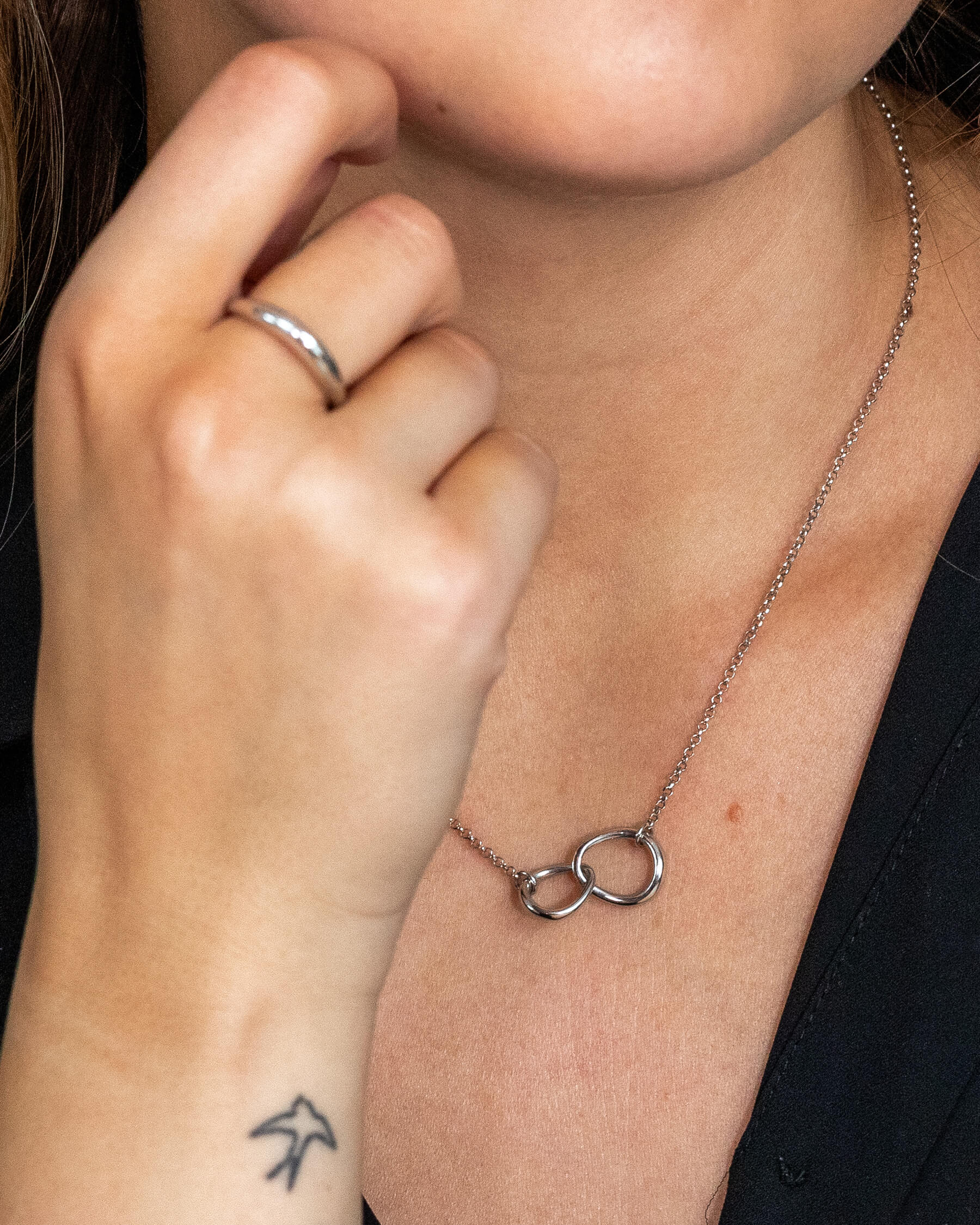 Kvinna med halsband i silver och en ring i silver.