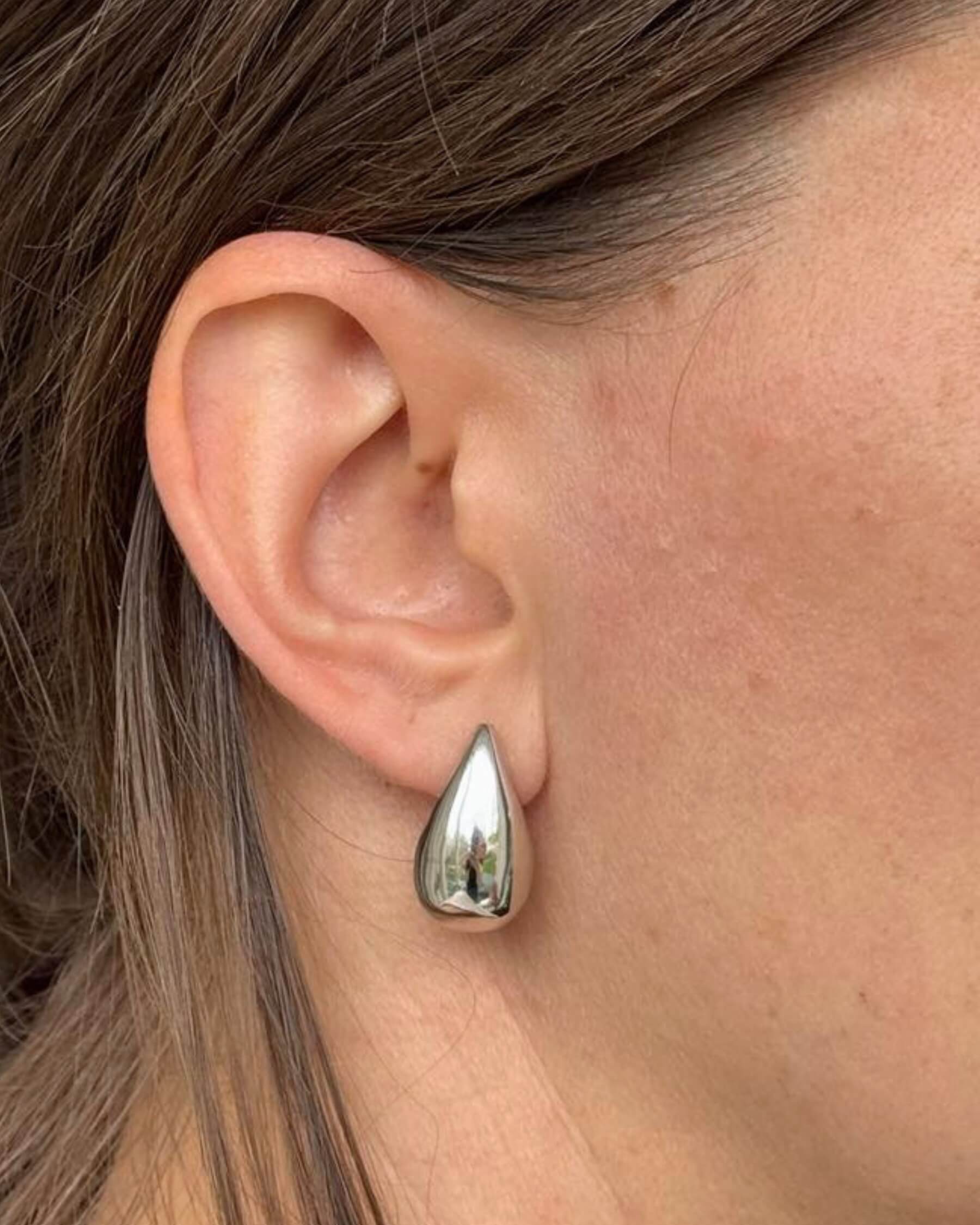 Öra med droppformat örhänge i rhodiumpläterat 925 sterling silver.