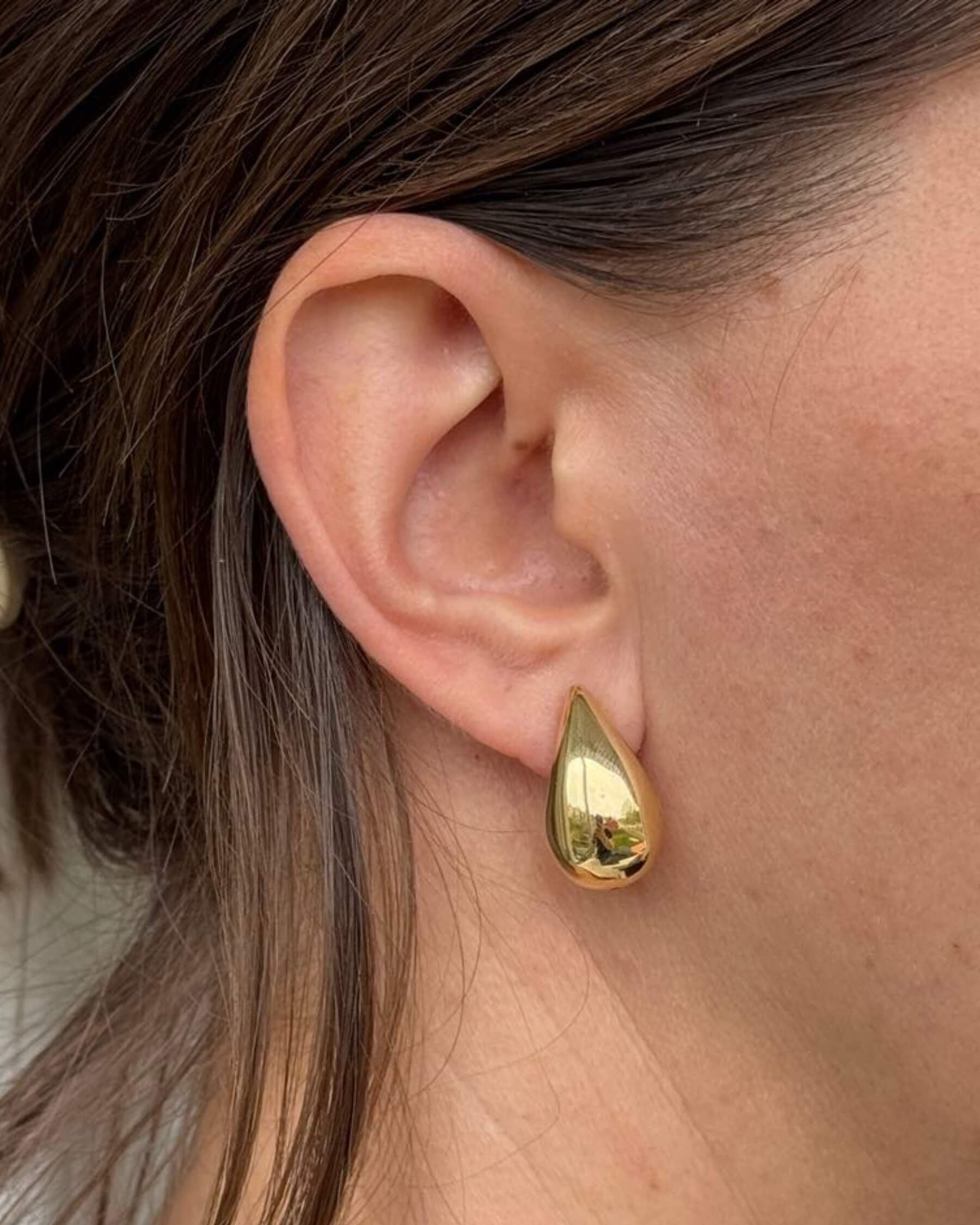 Öra med droppformat örhänge i guldpläterat 925 sterling silver.