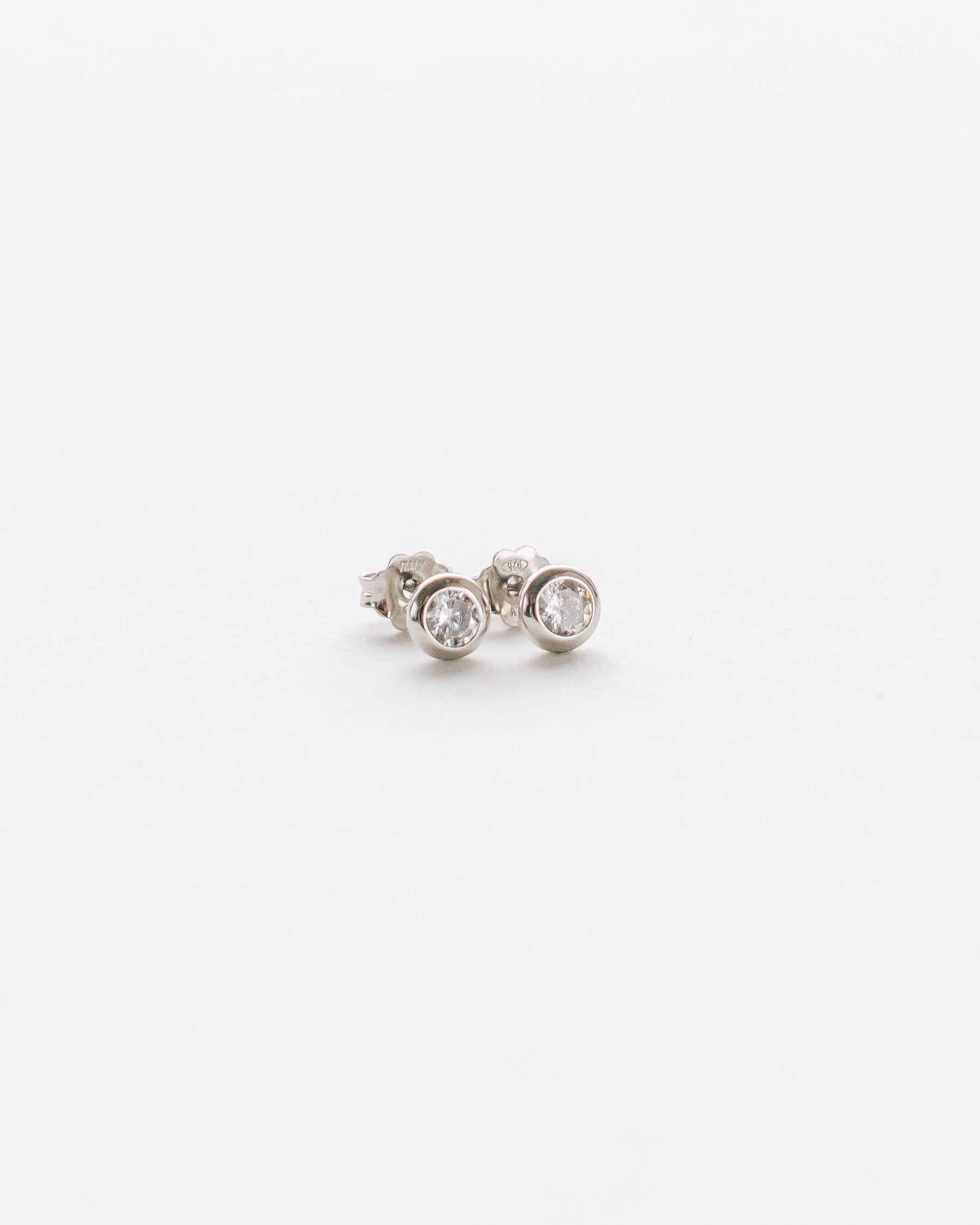 Små runda studs (örhängen) i 925 Sterling silver med vit Kubisk zirkonia i bezelfattning.