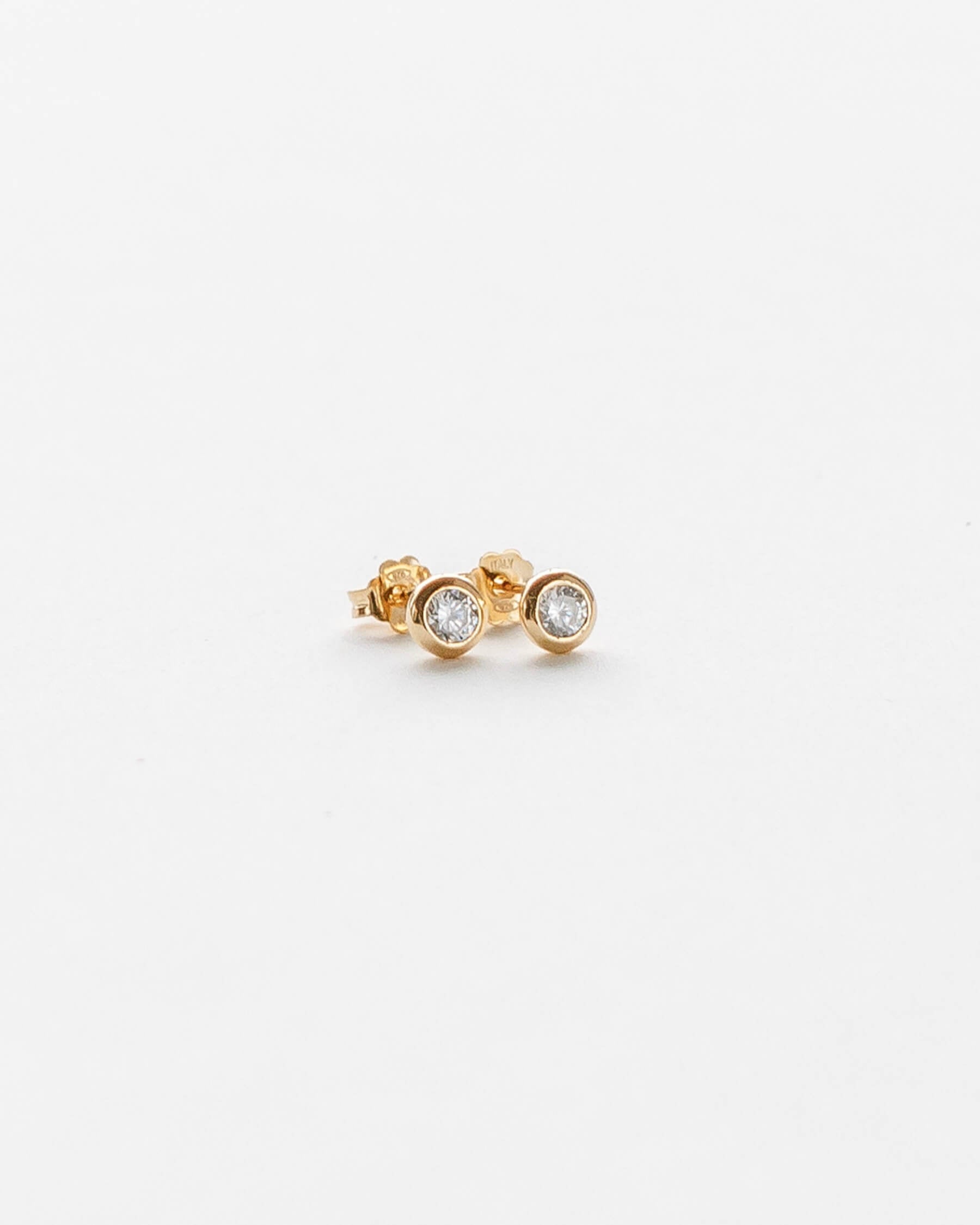 Små runda studs (örhängen) i guldpläterat 925 Sterling silver med vit Kubisk zirkonia i bezelfattning.