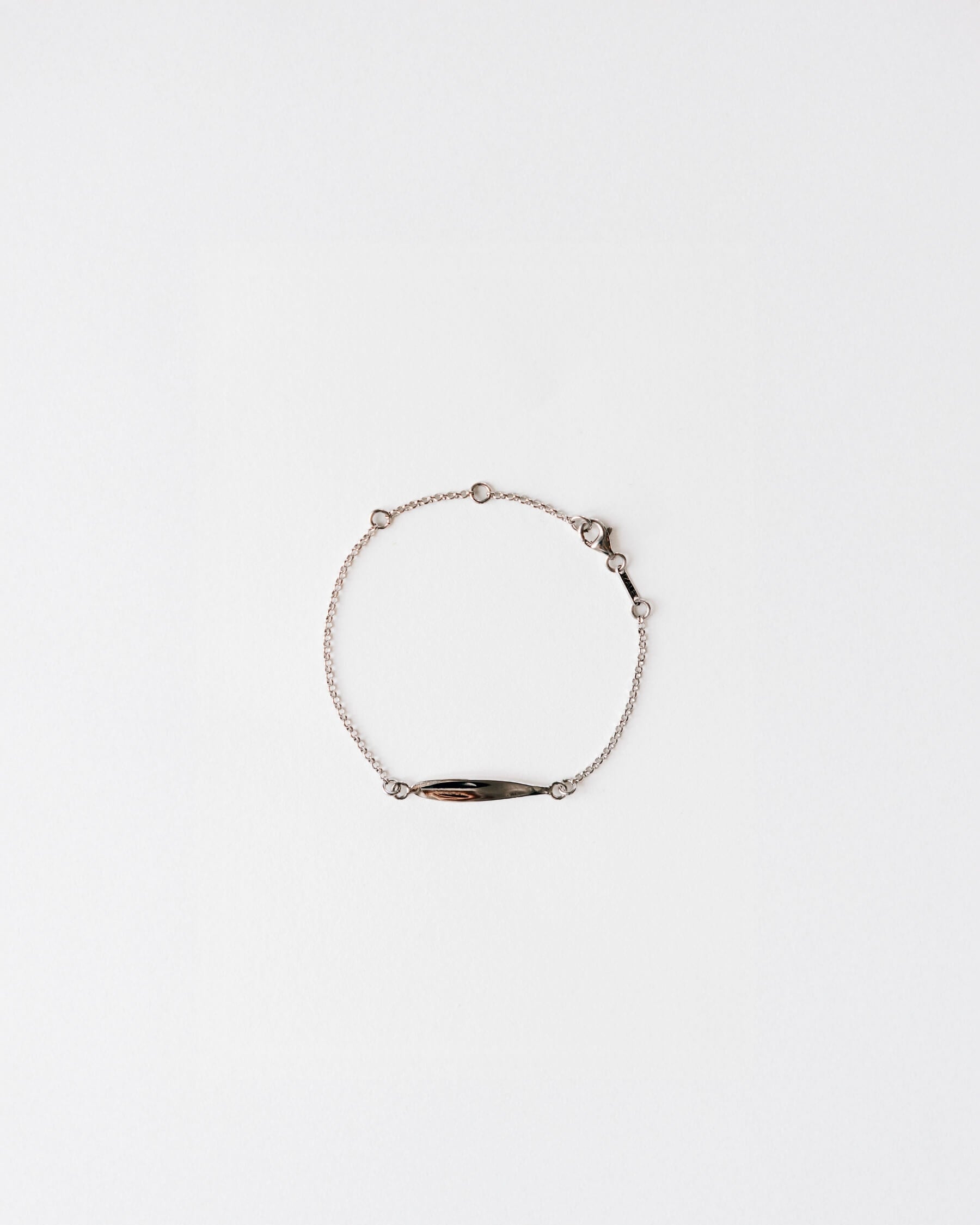 Tunn armkedja med  en stiliserad olivbladsformad platta i rhodiumpläterat 925 Sterling silver. 